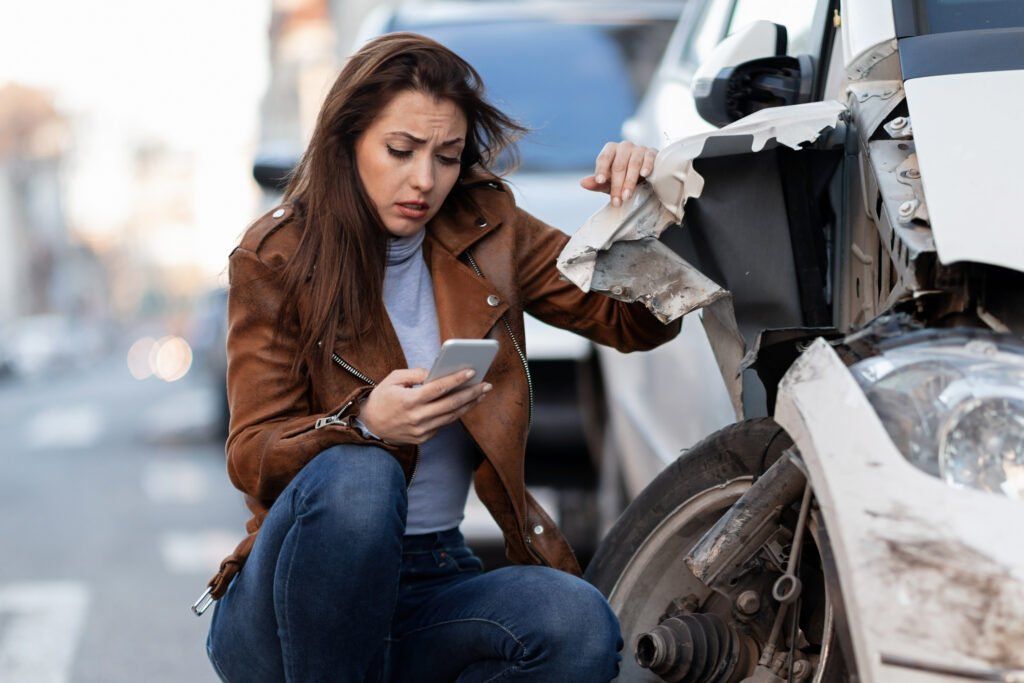 Woman beside a damaged car